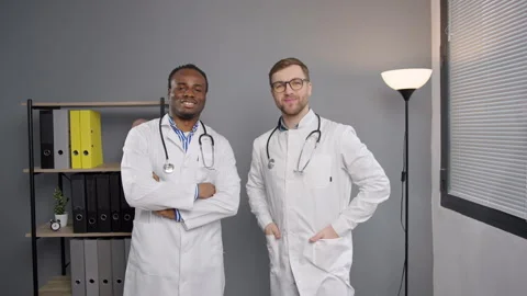 Two doctors looking at camera in hospital office Video stock 269510109