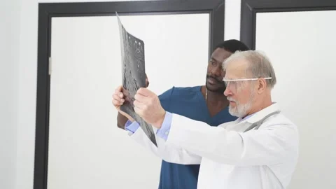 Two Doctors Looking At Computed Tomography X-ray Image, Discussing Stock Footage 150728484
