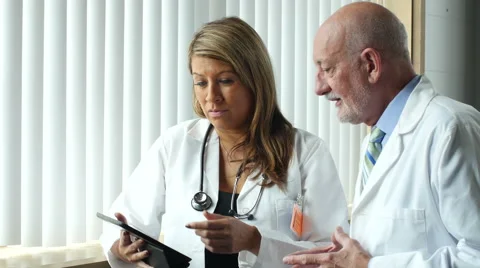 Two Doctors looking at tablet/ipad and consulting Stock-Footage 52333542