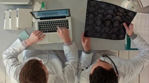 Two doctors men examine magnetic resonance imaging. Top view Видео 58162196