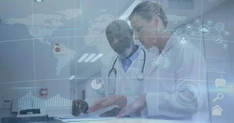 Two doctors pointing and reviewing healthcare data at nursing station, with Stock Footage 328010828