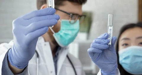 Two Doctors with protective gloves holding testing samples on Coronavirus Vídeo Stock 126558970