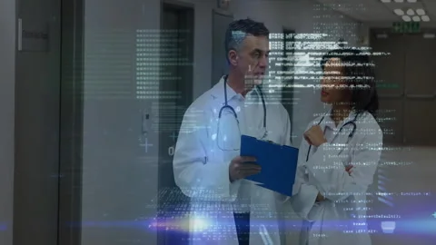 Two doctors reviewing clipboard notes sparking floating data overlays verifying Stock Footage 312415525