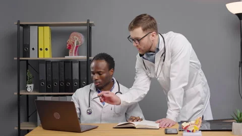 Two Doctors Reviewing Laptop Screen at Clinic Video stock 264985116