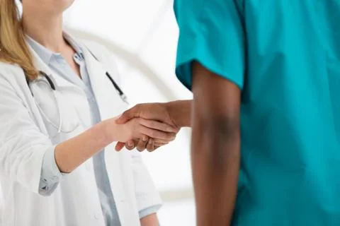 Two doctors shaking hands, mid section Stock Photos