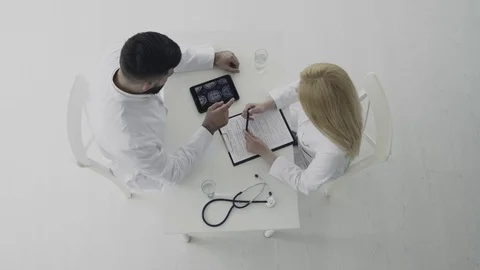 Two doctors speaking about a patient's log in hospital Stock Footage