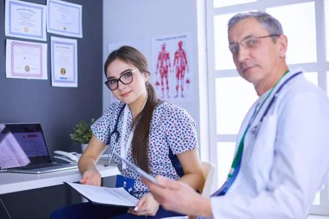 Two doctors speaking in a bright office Stock Photos