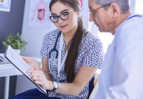 Two doctors speaking in a bright office Stock Photos