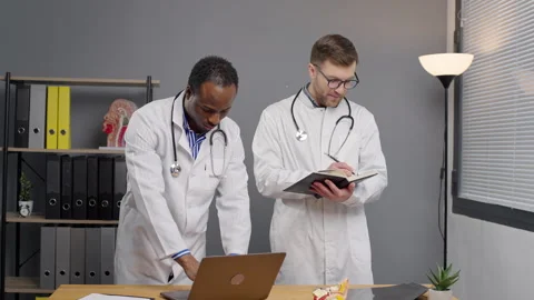 Two doctors Standing and speaking by Laptop in Clinic Stock-Footage 264981929