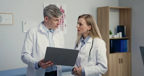 Two doctors talking about patients diagnosis using laptop to look at checkup Video stock 155635970