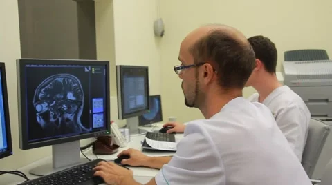 Two doctors watching the obtaining data from CT and MRI scanners (on dolly) Stock Footage
