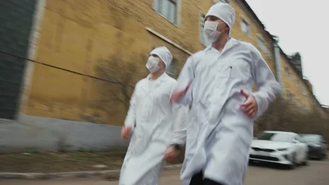 Two doctors in white coats, bonnets and masks run and lose an escaped patient Stock-Footage 190331761