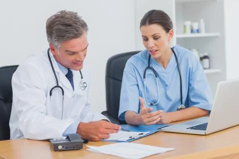 Two doctors working on an important folder Stock Photos