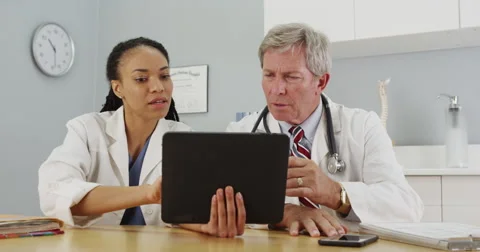 Two doctors working on tablet together Video stock 58350026