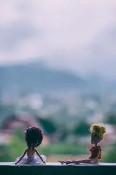 Two dolls sit on the windowsill Stock Photos