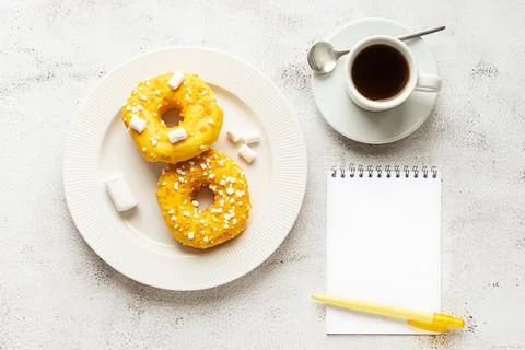 Two donuts, blank notepad and a cup of coffee Stock Photos
