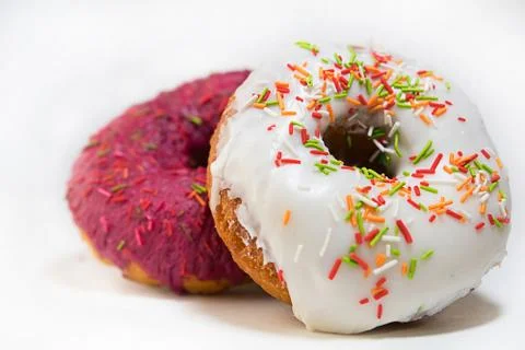 Two donuts covered with a red glaze top view on a white background Stock Photos