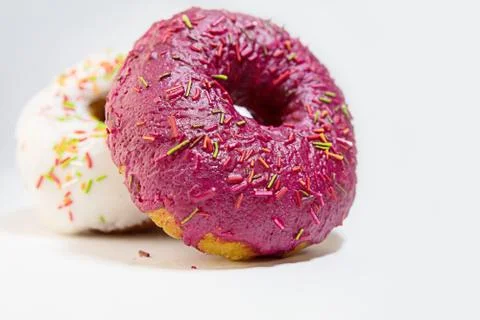 Two donuts covered with red glaze side view Stock Photos
