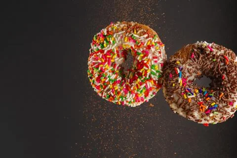 Two donuts on a gray background. Levitation. Holiday, birthday, anniversary,  Stock Photos
