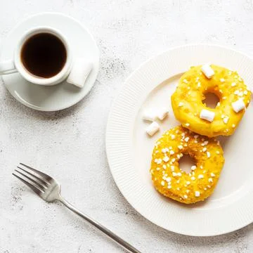 Two donuts with marshmallows and a cup of coffee Stock Photos