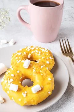 Two donuts with marshmallows and a cup of tea or coffee Stock Photos