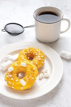 Two donuts with marshmallows and a cup of tea or coffee Stock Photos