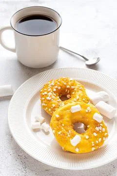 Two donuts with marshmallows and a cup of tea or coffee Stock Photos