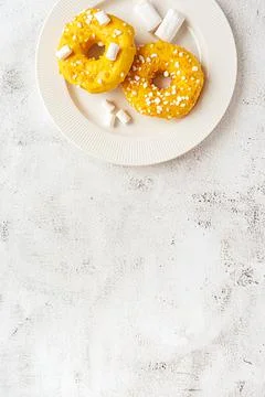 Two donuts with marshmallows served on a plate Stock Photos