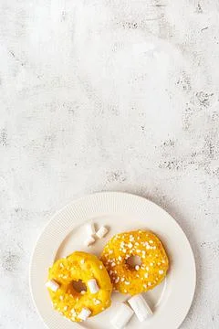 Two donuts with marshmallows served on a plate Stock Photos