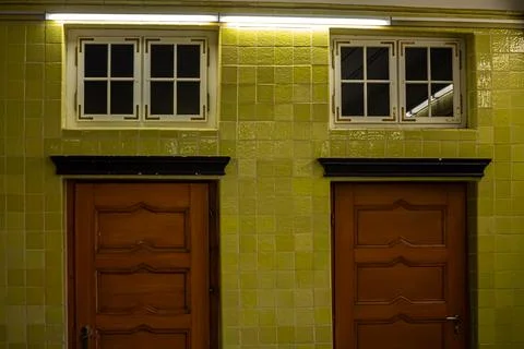 Two doors on a green tiled wall Stock Photos