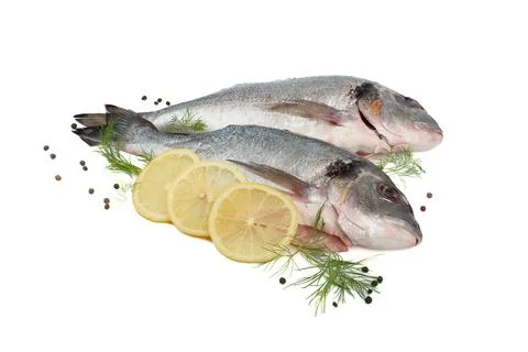 Two dorado fish with lemon, pepper and dill on a white background. Foto stock