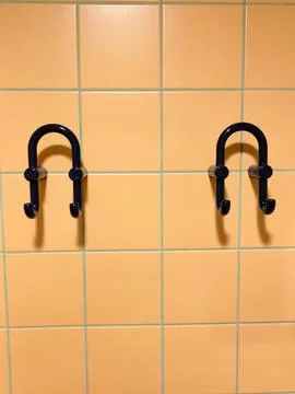 Two double blue plastic coat hooks on orange tiles Stock Photos