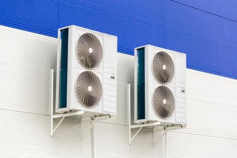 Two double condensing units of air conditioner on blue and white metal Stock Photos
