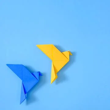 Two doves of peace on a blue background from a polygonal geometric toy. Stock Photos