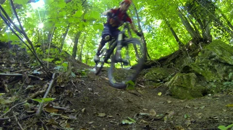 Two downhill cyclists passing fast by a low set camera fast Stock Footage 56354578