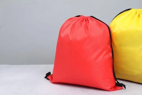 Two drawstring bags on light textured table. Space for text Stock Photos