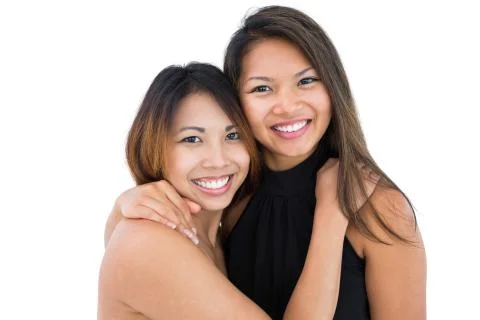 Two dressed up asian sisters embracing Stock Photos