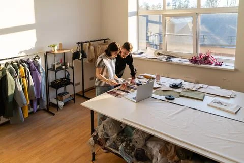 Two dressmaker work in studio with fabric samples for new collection. Team of Stock-Fotos