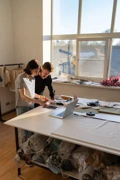 Two dressmaker work in studio with fabric samples for new collection. Team of Stock Photos