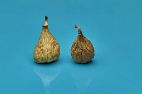 Two dried figs on blue background organic food still life Stock Photos