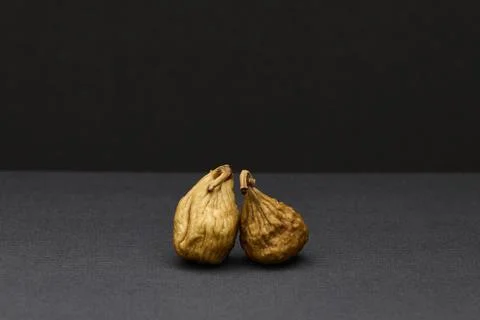 Two dried figs on dark gray background natural healthy snack Stock Photos