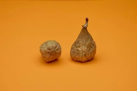 Two dried figs on orange background modern healthy food 写真素材