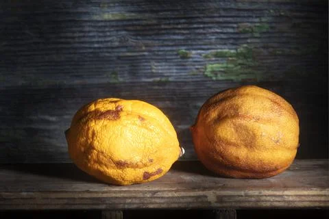 Two Dried Lemons in Sharp Light on Wooden Background Stock Photos
