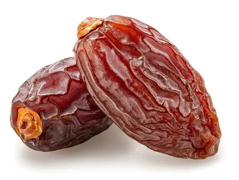 Two dried red dates with wrinkled skin on white background Stock Photos