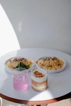 Two drinks with Rose Pasta Spaghetti placed in a white table Stock Photos
