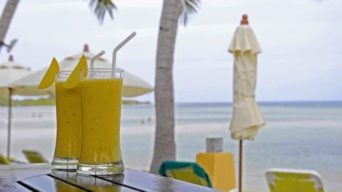 Two drinks on a table at the beach with background. Stock Footage 105834967