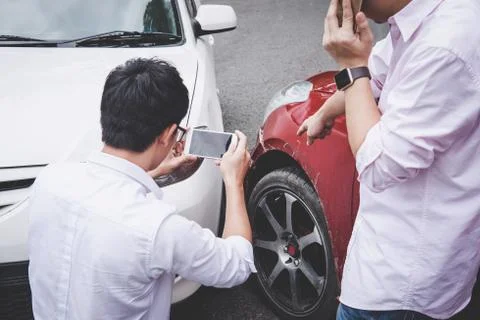 Two drivers man arguing after a car traffic accident collision and making pho Stock Photos