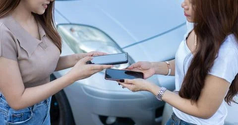 Two Drivers using a smartphone to exchange phone numbers and social media aft Stock Photos