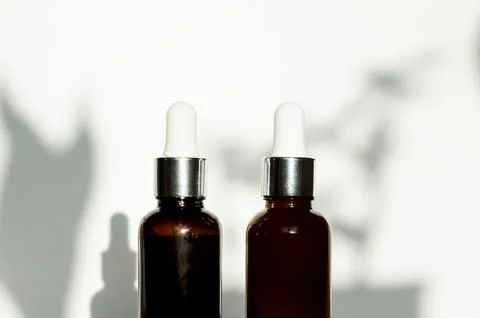 Two dropper bottles or vials or glass cosmetic jars without labels Foto stock