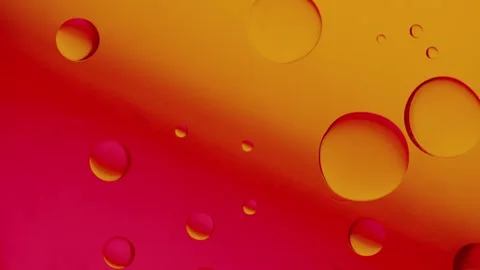 Two drops connect together on a red and yellow gradient background. 스톡 동영상 303059271